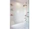 Bright bathroom featuring a white tub with glass door, modern fixtures and unique white, herringbone tile surround at 8155 Hunt Club Rd, Zionsville, IN 46077