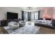 Spacious bedroom featuring hardwood floors, two chairs, large TV and a bed with neon sign at 8155 Hunt Club Rd, Zionsville, IN 46077
