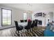 Formal dining room with ample natural light, a modern light fixture, and a fireplace for a cozy and stylish dining experience at 8155 Hunt Club Rd, Zionsville, IN 46077