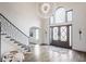 Grand foyer with high ceilings, designer chandelier, hardwood floors, and elegant staircase with iron railings at 8155 Hunt Club Rd, Zionsville, IN 46077