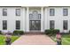 Inviting front entrance with a brick pathway, stately columns, and lush landscaping featuring elegant flower pots at 8155 Hunt Club Rd, Zionsville, IN 46077