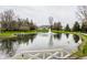Scenic view of a pristine pond with a fountain, complemented by the estate's grand residence in the background at 8155 Hunt Club Rd, Zionsville, IN 46077