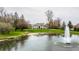 Picturesque view of the estate's lush grounds, featuring a fountain and the stately home nestled among mature trees at 8155 Hunt Club Rd, Zionsville, IN 46077