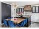 The kitchen boasts a large island, custom vent hood, modern lighting, and a breakfast area with stylish blue chairs at 8155 Hunt Club Rd, Zionsville, IN 46077