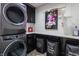 Modern laundry room featuring front load washer and dryer with black cabinetry and deluxe laundry service bins at 8155 Hunt Club Rd, Zionsville, IN 46077