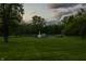 Expansive property featuring a picturesque pond with fountain, surrounded by mature trees and manicured lawns at 8155 Hunt Club Rd, Zionsville, IN 46077