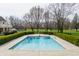 Beautiful in-ground pool surrounded by lush greenery and manicured hedges in a serene backyard at 8155 Hunt Club Rd, Zionsville, IN 46077