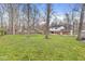 Wide-open green backyard and brick back of house with multiple trees for privacy at 8715 Kensington Dr, Noblesville, IN 46060
