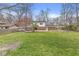 Brick and white house shows the expansive, lush green yard with trees and a wooden fence at 8715 Kensington Dr, Noblesville, IN 46060
