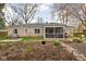 Charming back exterior featuring a screened-in porch, manicured garden beds, and a cozy seating area at 928 Forest Blvd N Dr, Indianapolis, IN 46240