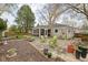 Back exterior featuring a well-manicured yard, stone patio, screened-in porch, and lush greenery at 928 Forest Blvd N Dr, Indianapolis, IN 46240