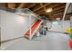 Unfinished basement featuring painted white block walls, exposed ceiling beams, and red painted stairs at 928 Forest Blvd N Dr, Indianapolis, IN 46240