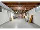 Spacious basement with painted white block walls, exposed wooden beams, and concrete floor at 928 Forest Blvd N Dr, Indianapolis, IN 46240