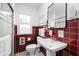 Retro bathroom featuring red tiled walls, a pedestal sink, and a glass enclosed shower at 928 Forest Blvd N Dr, Indianapolis, IN 46240