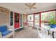 Inviting screened porch with red trim, stone wall, tile flooring, and comfortable seating creating a cozy outdoor space at 928 Forest Blvd N Dr, Indianapolis, IN 46240
