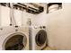 The basement laundry area features a side-by-side washer and dryer on a concrete floor at 933 Tecumseh St, Indianapolis, IN 46201
