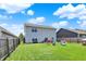 Expansive backyard with lush green grass, outdoor seating, fire pit, and modern home exterior at 950 Redwood Dr, Franklin, IN 46131