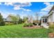 Serene backyard showcasing a lush lawn, elegant patio furniture, barbecue grill, and manicured landscape beds at 10235 Normandy Way, Fishers, IN 46040
