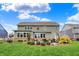 Backyard featuring a patio with comfortable seating, lush landscaping, and the home's neutral-colored exterior at 10235 Normandy Way, Fishers, IN 46040