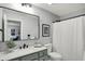 Stylish bathroom features a sleek vanity, black hardware, framed mirror, and a shower with a white curtain at 10235 Normandy Way, Fishers, IN 46040
