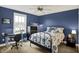 Blue bedroom featuring a metal bed frame, a ceiling fan, a window, and dark dresser and nightstand at 10235 Normandy Way, Fishers, IN 46040