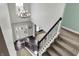 Grand foyer view from the upper staircase landing, highlighting the entrance, hardwood floors, and lighting fixture at 10235 Normandy Way, Fishers, IN 46040