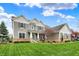 Inviting two-story home with a well-manicured lawn, neutral siding, brick accents, and a charming teal-colored front door at 10235 Normandy Way, Fishers, IN 46040