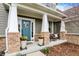 Inviting front porch featuring potted plants, a cozy seating area, and a cheerful teal front door at 10235 Normandy Way, Fishers, IN 46040