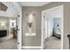 A hallway featuring decorative nooks and views of a well-lit bathroom and a sitting room with a comfortable chair at 10235 Normandy Way, Fishers, IN 46040