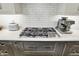 Modern kitchen cooktop with sleek countertops, subway tile backsplash, and stainless steel appliances at 10235 Normandy Way, Fishers, IN 46040