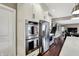 Kitchen area with stainless steel appliances next to the staircase at 10235 Normandy Way, Fishers, IN 46040
