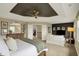 Large bedroom features a tray ceiling, a comfortable bed, dresser and a cozy sitting area at 10235 Normandy Way, Fishers, IN 46040