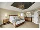 Spacious bedroom with a decorative tray ceiling, wooden furniture, and ample natural light at 10235 Normandy Way, Fishers, IN 46040