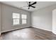 Bright bedroom featuring dark wood-look floors, ceiling fan, and natural light at 1200 Shadow Ridge Rd, Carmel, IN 46280