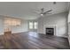 Open living room features dark wood floors, modern ceiling fan, and fireplace with white mantel at 1200 Shadow Ridge Rd, Carmel, IN 46280