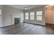 Bright living area boasts dark wood floors, fireplace, multiple windows, and elegant ceiling fan at 1200 Shadow Ridge Rd, Carmel, IN 46280