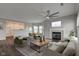 Open-concept living room with fireplace, ceiling fan, modern furniture, and seamless flow to kitchen and dining areas at 1200 Shadow Ridge Rd, Carmel, IN 46280