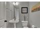 Cozy half bathroom with pedestal sink, toilet, and decorative artwork on the wall at 12027 Sellerton Dr, Fishers, IN 46037