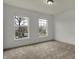 This bedroom has neutral carpeting and two large double-hung windows with neighborhood views at 12027 Sellerton Dr, Fishers, IN 46037