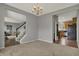 Carpeted living room with a view of the staircase and entry to the kitchen at 12027 Sellerton Dr, Fishers, IN 46037