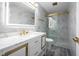 Modern bathroom features an illuminated mirror, marble countertops, and sleek fixtures for a contemporary look at 12516 Schoolhouse Rd, Fishers, IN 46037