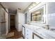 Modern bathroom featuring double sinks, marble countertops, illuminated mirror, and luxurious gold fixtures at 12516 Schoolhouse Rd, Fishers, IN 46037