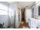 Bright bathroom with marble tile, glass shower, and wood look flooring creates a luxurious and modern retreat at 12516 Schoolhouse Rd, Fishers, IN 46037
