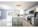 Well-lit, open-concept kitchen with stainless steel appliances, a modern island, and view to the outdoor patio at 12516 Schoolhouse Rd, Fishers, IN 46037