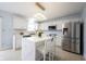 Bright and modern kitchen with stainless steel appliances, white cabinets, an island with seating, and quartz countertops at 12516 Schoolhouse Rd, Fishers, IN 46037