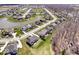 An aerial view of a neighborhood featuring well-maintained lawns, mature trees, and a pond, offering a serene and picturesque setting at 12598 Coastal Pl, Fishers, IN 46037