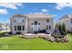 Backyard view of outdoor seating, fire pit, green grass, and manicured landscaping at 12598 Coastal Pl, Fishers, IN 46037