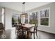 Bright dining room with large windows and backyard access, showcasing a stylish wooden table and chairs at 12598 Coastal Pl, Fishers, IN 46037