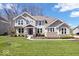 Charming two-story home with a well-manicured lawn, stone accents, and a welcoming front porch at 12598 Coastal Pl, Fishers, IN 46037