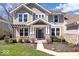 Inviting home facade with stone accents, a covered entryway, and a manicured garden at 12598 Coastal Pl, Fishers, IN 46037